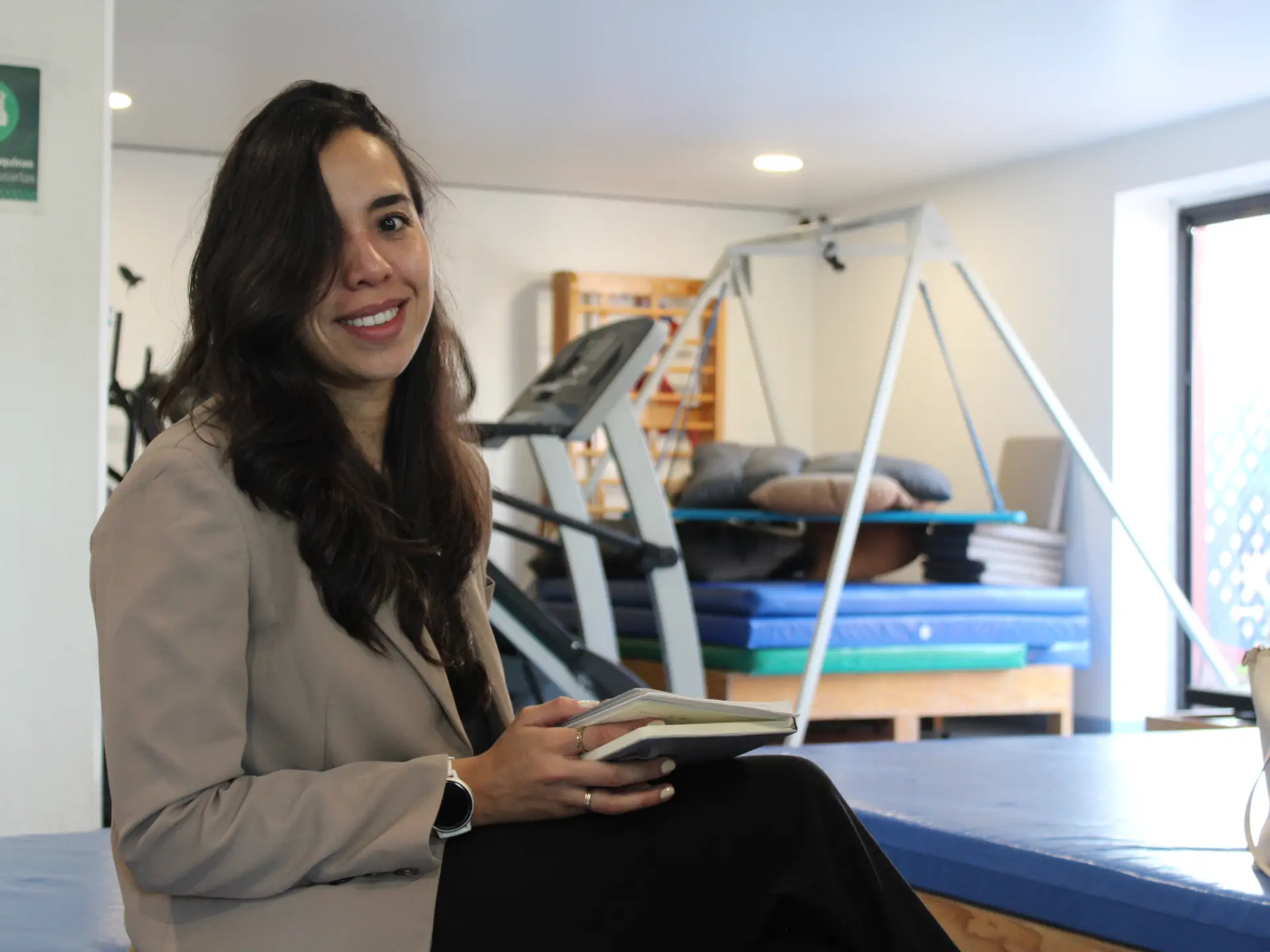 Profesional sonriente en un centro de rehabilitación con equipo terapéutico